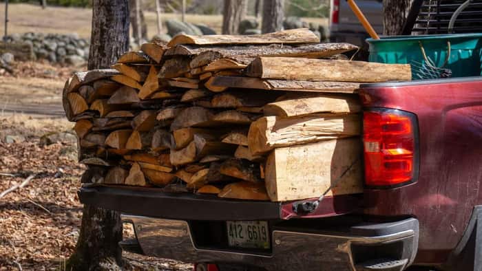 A pickup truck loaded with a full cord of split firewood, ready for delivery